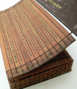 A Chinese bamboo book, open to display the binding and contents. This copy of The Art of War (on the cover, 