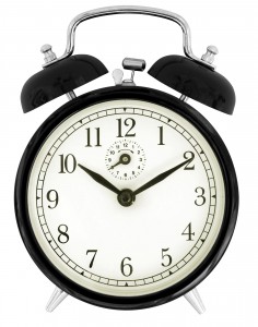 The face of a black windup alarm clock