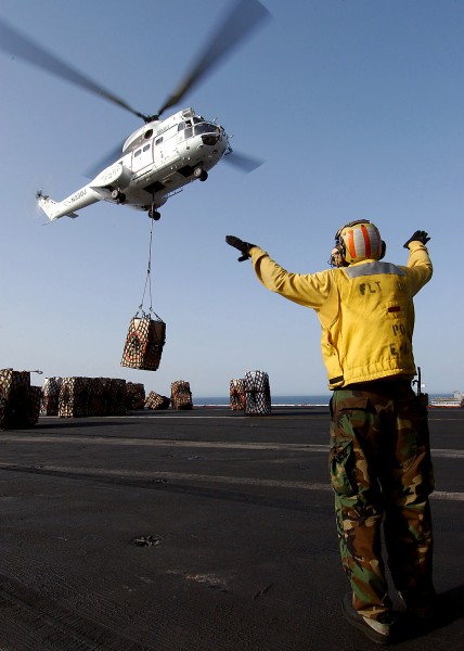 US Navy 040527-N-7871M-047 Aviation Boatswain's Mate 2nd Class Francis Gardner, of Waukegan, Ill., directs an Aerospatiale SA330 Puma helicopter after picking up a pallet of supplies