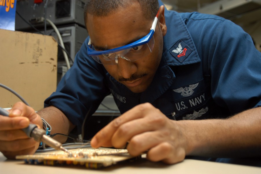 US Navy 040831-N-7568S-002 Aviation Electronics Technician 2nd Class Kevin Williams, of Decatur, Ga., repairs a circuit card for a UPM-136 transponder