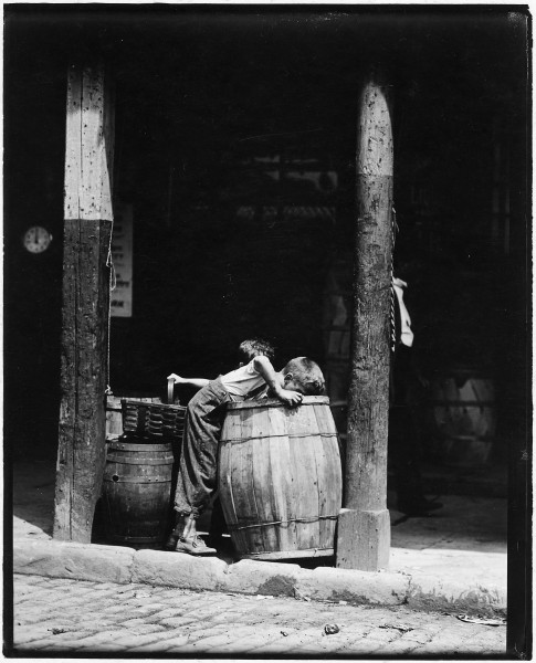 No caption. Young boy looking in barrel. - NARA - 523330
