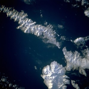 Aleutian Islands from space A photograph of Atka Island, Amlia Island, and other parts of the Aleutian chain, Alaska. Taken on the STS-56 shuttle mission, in April 1993. Image number: STS056-071-031 The oval, snow-covered northern peninsula of Atka Island, a cluster of severely eroded stratovolcanoes and caldera, is part of the Aleutian chain known as the Central Aleutian Islands. Korovin Volcano, near the northern edge of the island, has the highest elevation on the island [5030 feet (1533 meters)] and the most eruptive activity. Elongated, east-west-oriented Amlia Island to the east rises only 2100 feet (640 meters) at its highest elevation.