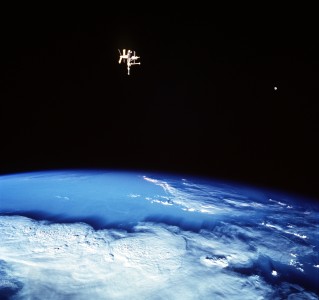 Mir and the Moon, two satellites of the Earth :While orbiting the planet during their June 1998 mission, the crew of the Space Shuttle Discovery photographed this view of two moons of Earth. Thick storm clouds are visible in the lovely blue planet's nurturing atmosphere and, what was then Earth's largest artificial moon, the spindly Russian Mir Space Station can be seen above the planet's limb. The bright spot to the right of Mir is Earth's very large natural satellite, The Moon. The Mir orbited planet Earth once every 90 minutes about 200 miles above the planet's surface or about 4,000 miles from Earth's center. The Moon orbits once every 28 days at a distance of about 250,000 miles from the center of the Earth.