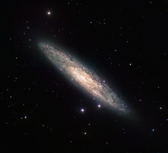 Measuring 70 000 light-years across and lying 13 million light-years away, the nearly edge-on spiral galaxy NGC 253 is revealed here in an image from the Wide Field Imager (WFI) of the MPG/ESO 2.2 m telescope at the La Silla Observatory. The image is based on data obtained through four different filters (R, V, H-alpha and OIII). North is up and East to the left. The field of view is 30 arcminutes.
