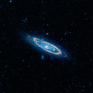 The immense Andromeda galaxy, also known as Messier 31 (M31), is captured in full in this new image from NASA's Wide-field Infrared Survey Explorer (WISE). The mosaic covers an area equivalent to more than 100 full moons, or five degrees across the sky. WISE used all four of its infrared detectors to capture this picture (3.4- and 4.6-micron light is colored blue; 12-micron light is green; and 22-micron light is red). Blue highlights mature stars, while yellow and red show dust heated by newborn, massive stars.
Andromeda is the closest large galaxy to our Milky Way galaxy, and is located 2.5 million light-years from our sun. It is close enough for telescopes to spy the details of its ringed arms of new stars and hazy blue backbone of older stars. Also seen in the mosaic are two satellite galaxies: M32, located just a bit above Andromeda to the left of center, and the fuzzy blue M110, located below the center of the great spiral arms. These satellites are the largest of several that are gravitationally bound to Andromeda.
Andromeda is larger than the Milky Way and contains more stars, but the Milky Way is thought to perhaps have more mass due to its larger proportion of a mysterious substance called dark matter. Both galaxies belong to our so-named Local Group, a collection of more than 50 galaxies, most of which are tiny dwarf systems. In its quest to map the whole sky, WISE will capture the entire Local Group.
