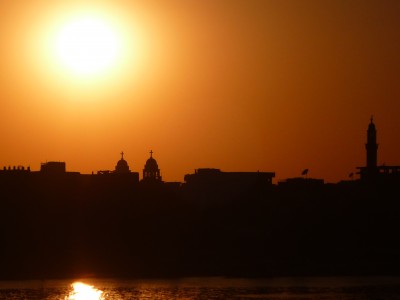 Esna sunset with minaret and copt bells tower, Egypt