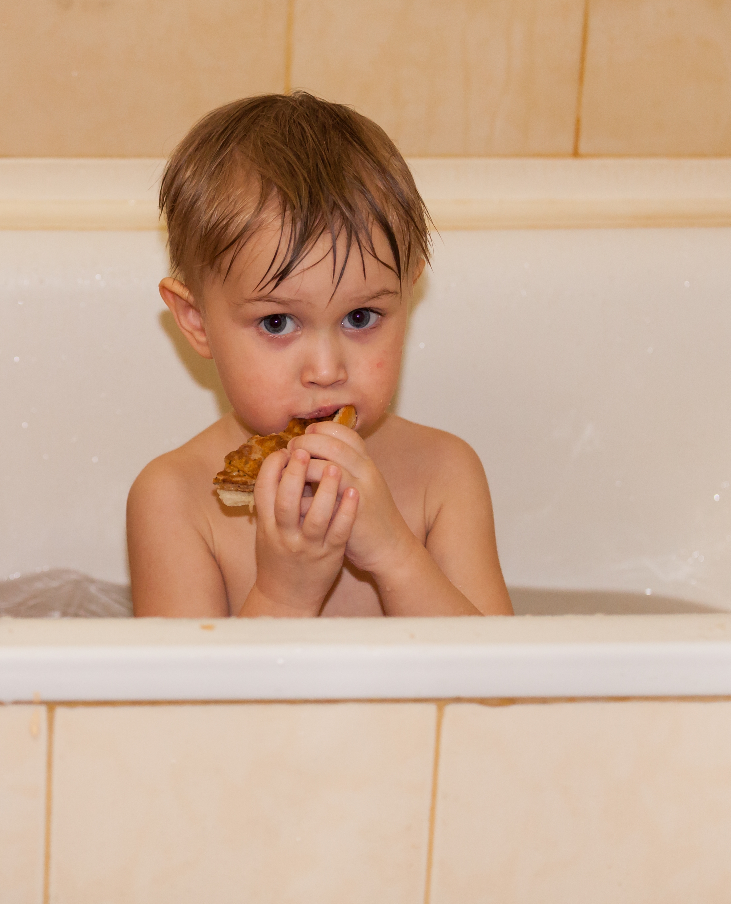 a 3-year-old boy having a snack in a bathtub in March 2016