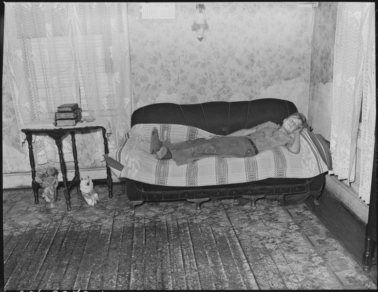 Child of Murray Price, miner, asleep on couch where he normally sleeps at night. Black Mountain Corporation, 30-31... - NARA - 541262