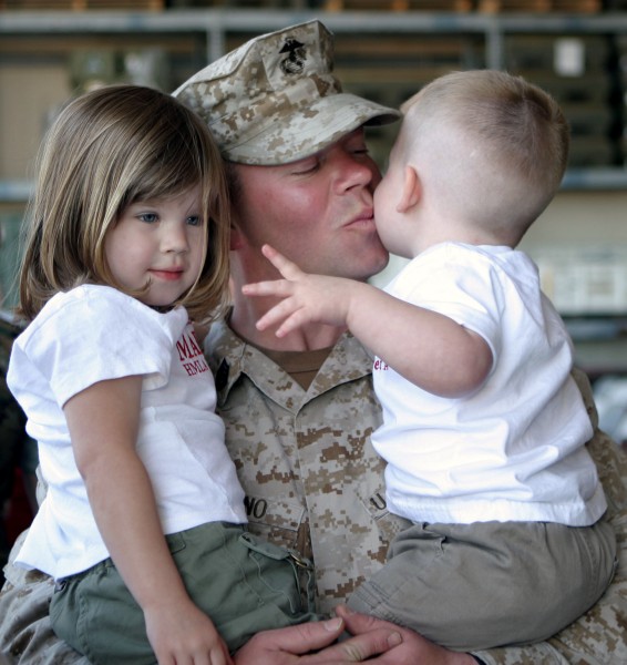 US Navy 040331-M-2270C-013 U.S. Marine Corps Gunnery Sgt. Kory Marino, assigned to the “Red Dogs” of Marine Light Attack Helicopter Squadron Seven Seven Three (HMLA-773), Detachment A, holds and kisses his son and daughter