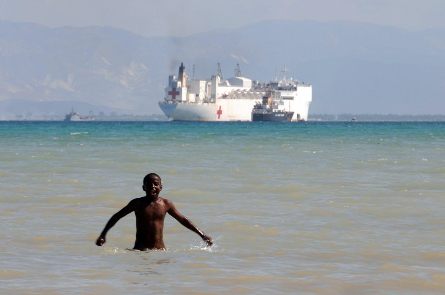US Navy 100204-N-3592S-202 A Haitian boy plays in the water with the Military Sealift Command hospital ship USNS Comfort (T-AH 20) visible off the coast
