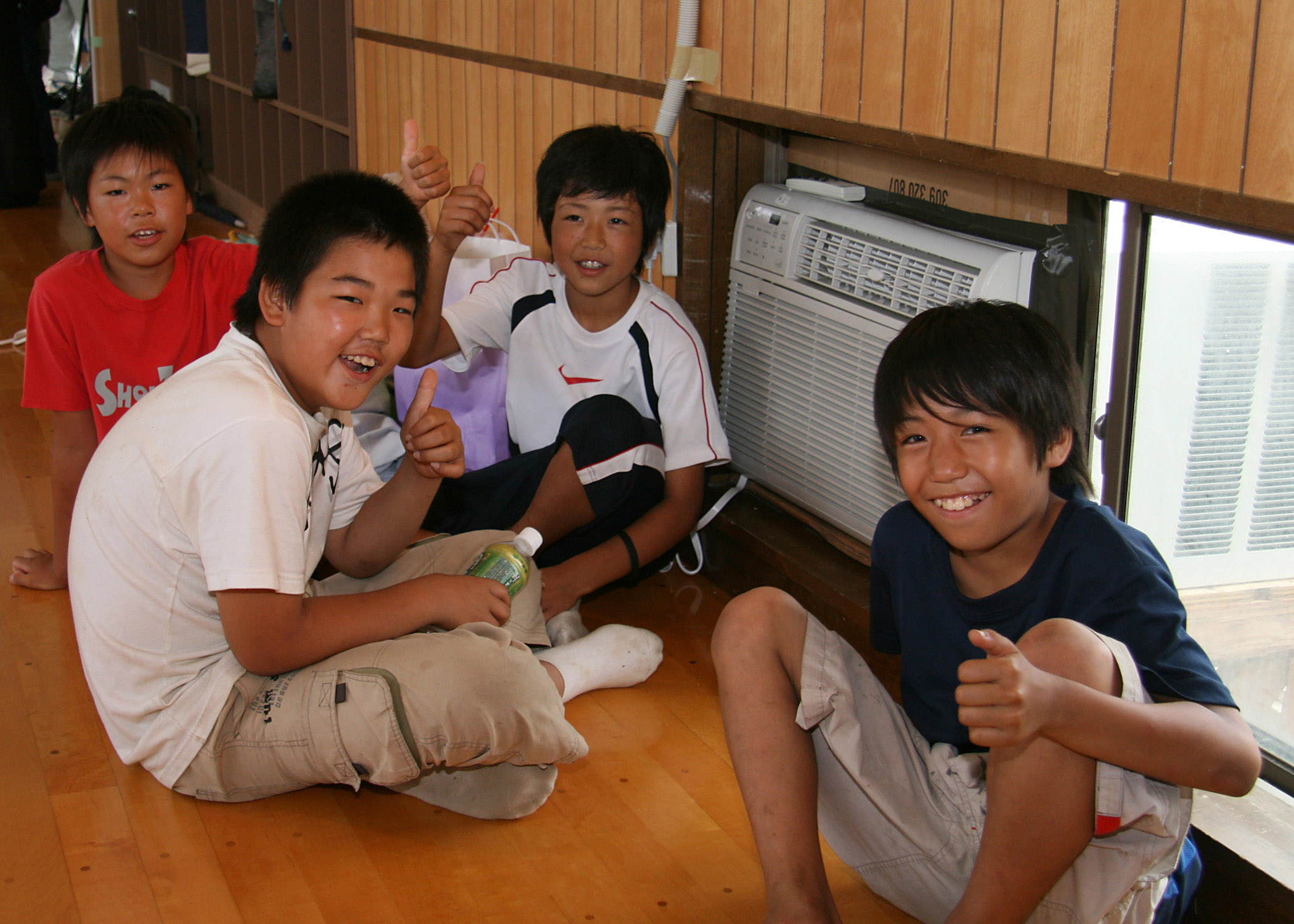 US Navy 070720-N-4270H-014 Four Japanese boys show their appreciation for the newly installed air conditioning units at the Arahama Community Center