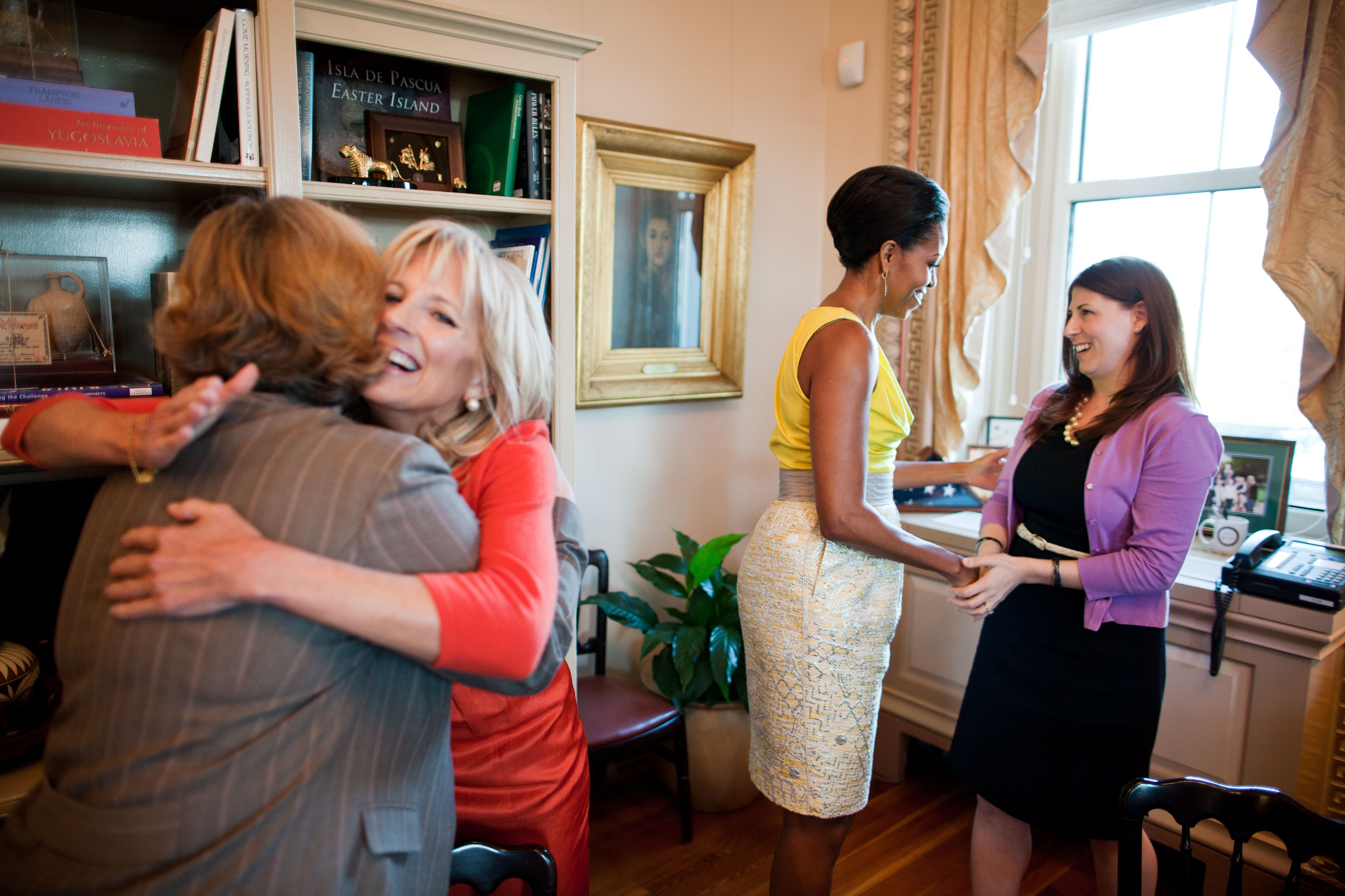 Jill Biden and Michelle Obama greet participants during a roundtable meeting, 2011