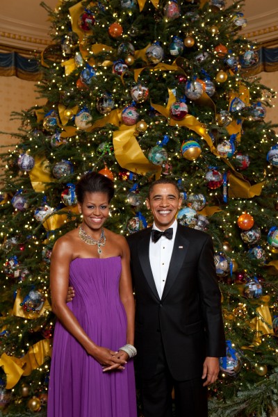 Michelle and Barack Obama pose in front of the official White House Christmas Tree