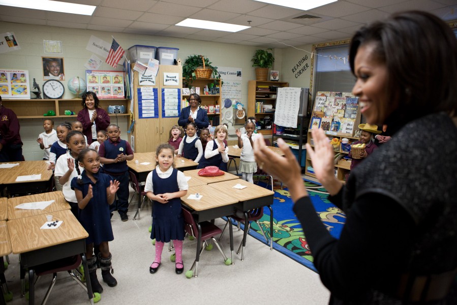 Michelle Obama claps along with students as they sing, 2011