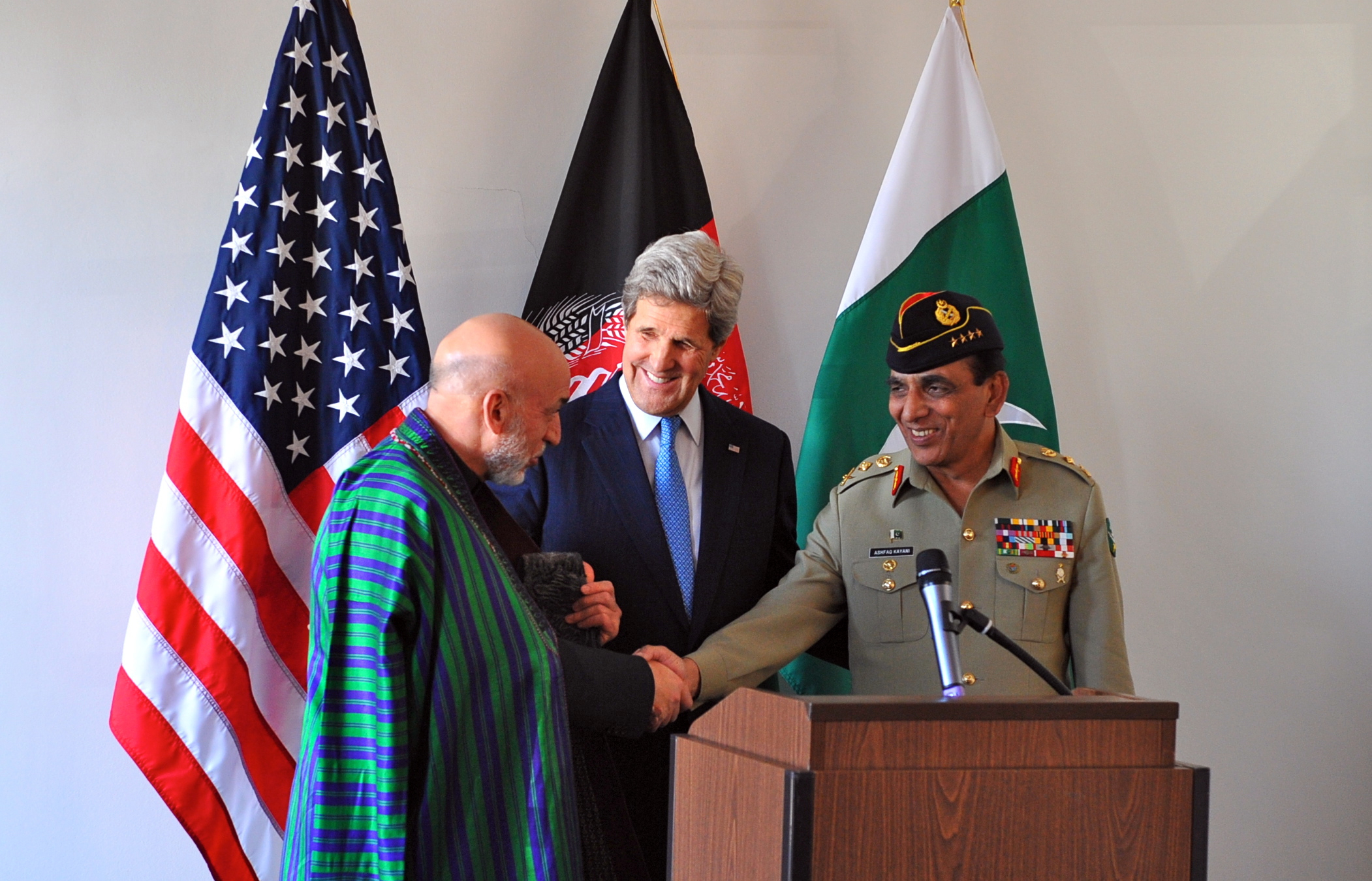 U.S. Secretary of State John Kerry looks on as Afghan President Hamid Karzai and Pakistani Chief of Army Staff General Ashfaq Kayani shake hands after their trilateral meeting in Brussels, Belgium, on April 24, 2013