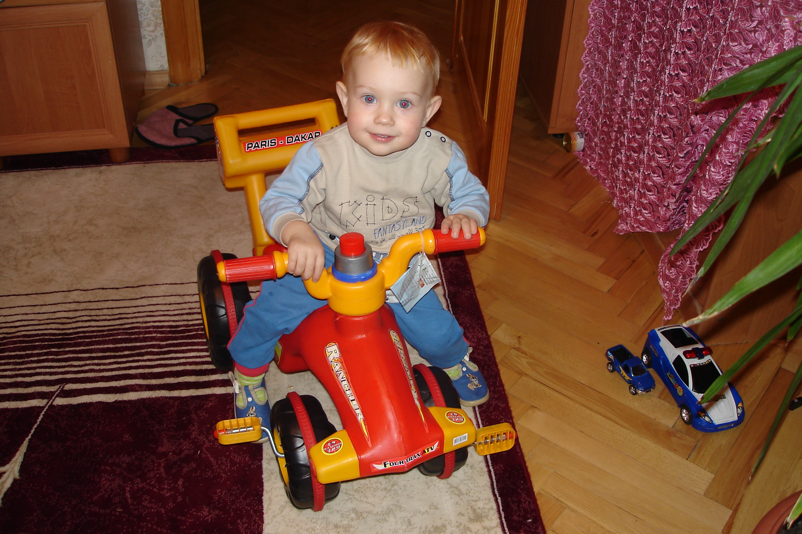 A small boy on a plastic bicycle.