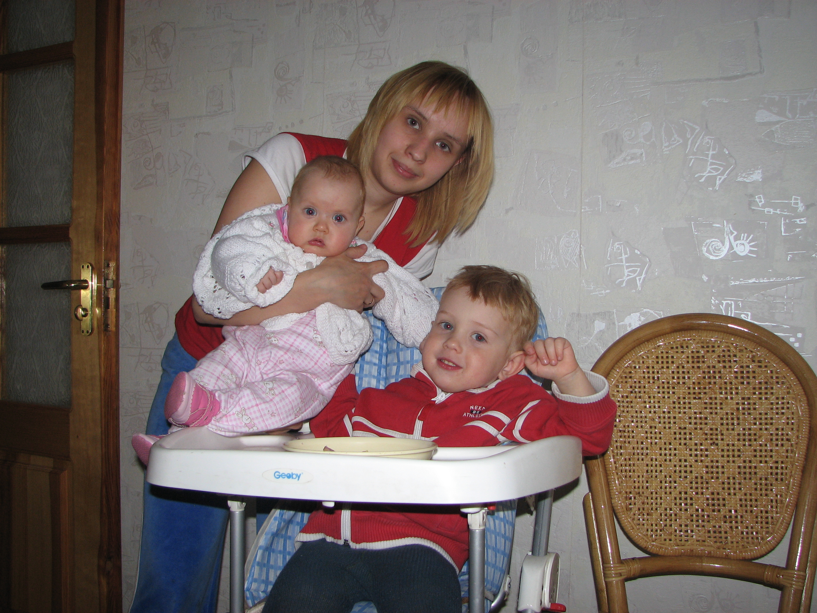 Mother with her baby kids at a table for babies, family.