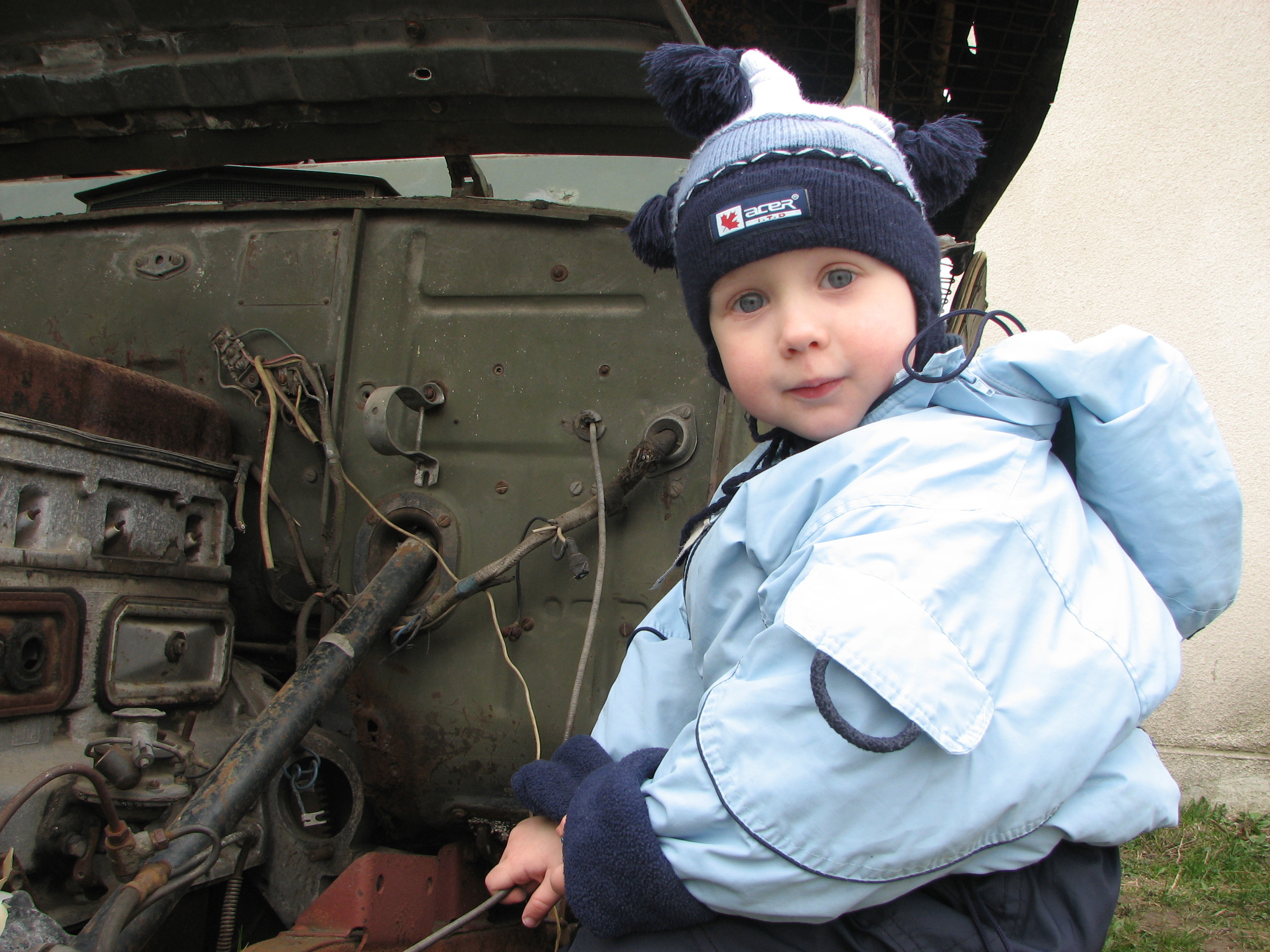A small boy studying an old car