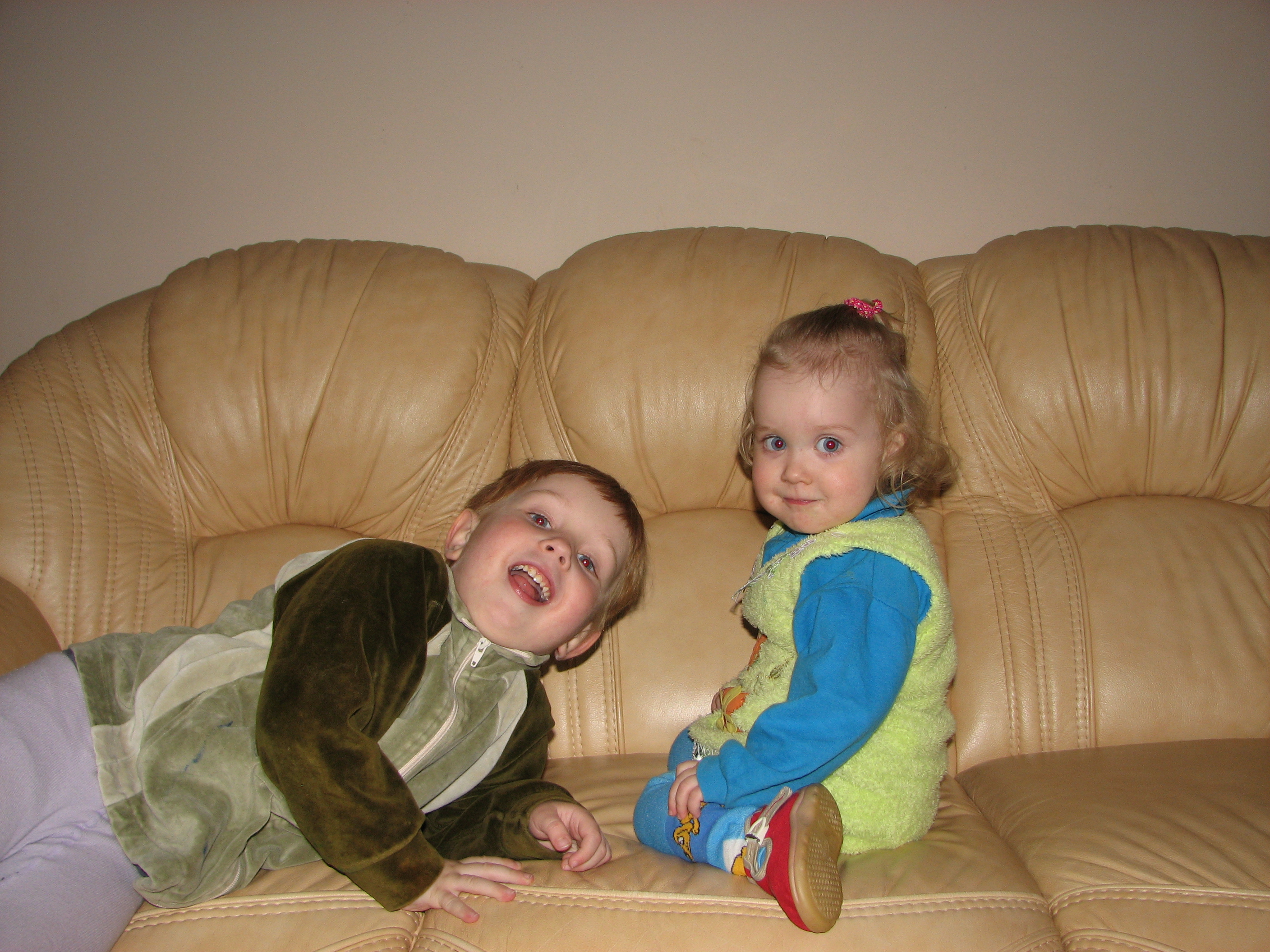 Brother and sister, small children, on a leather sofa