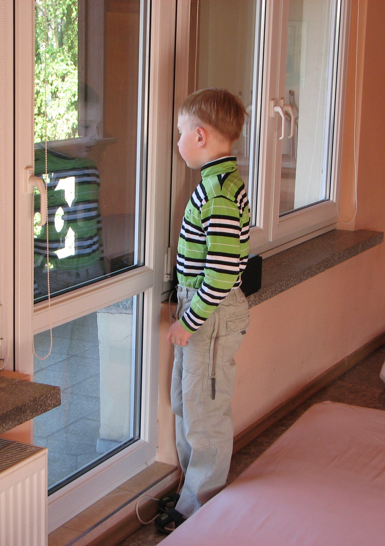 A 7-year old boy looking out the window
