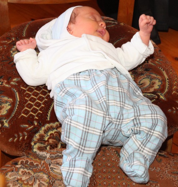 a cute Catholic baby lying on a chair, picture 1
