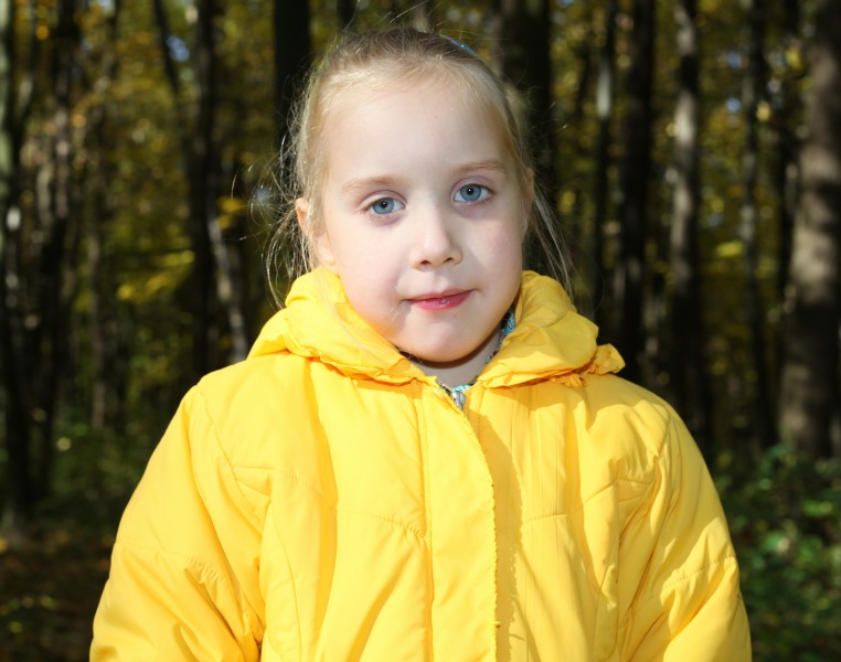 a cute blond Catholic child girl in a forest, picture 1