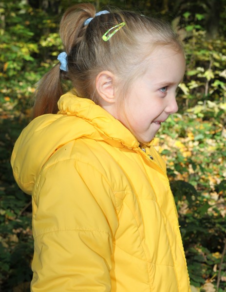 a cute smiling blond Catholic child girl in profile, in a forest, picture 3