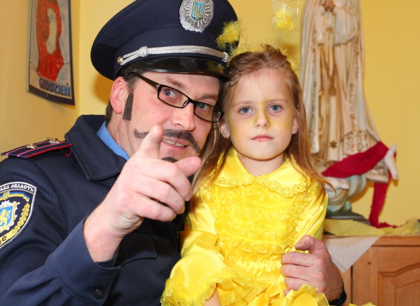 a Catholic man dressed-up as a policeman with a cute child girl