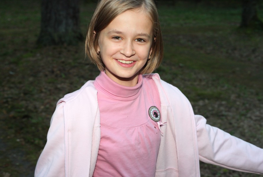 an appealing young smiling Catholic girl in a park, picture 1