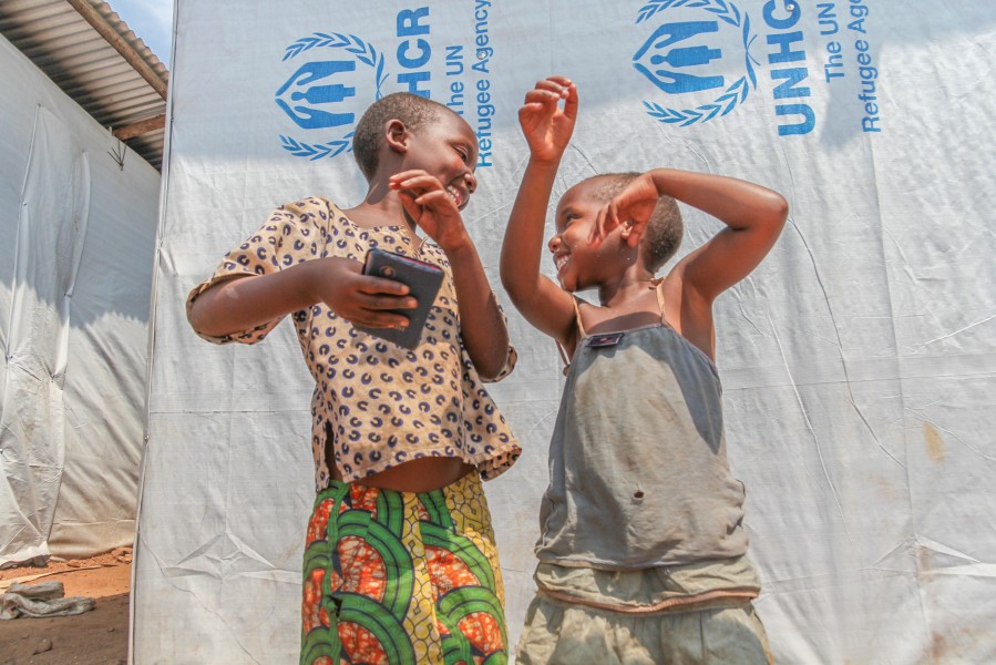 Congolese children holding a bible singing the gospel song in front of the UNHCR tent in Mugombwa refugee camp in Rwanda