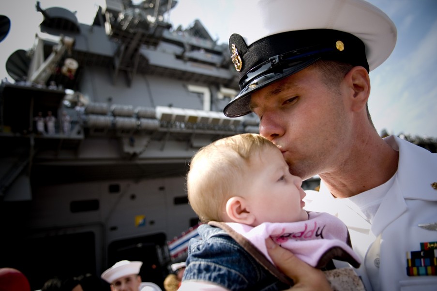 US Navy 080925-N-5549O-211 Chief Aviation Machinist Mate David Lyman gives his newborn daughter Emily a kiss during a ceremony for the arrival of the aircraft carrier USS George Washington (CVN 73) to its new home port in Japan