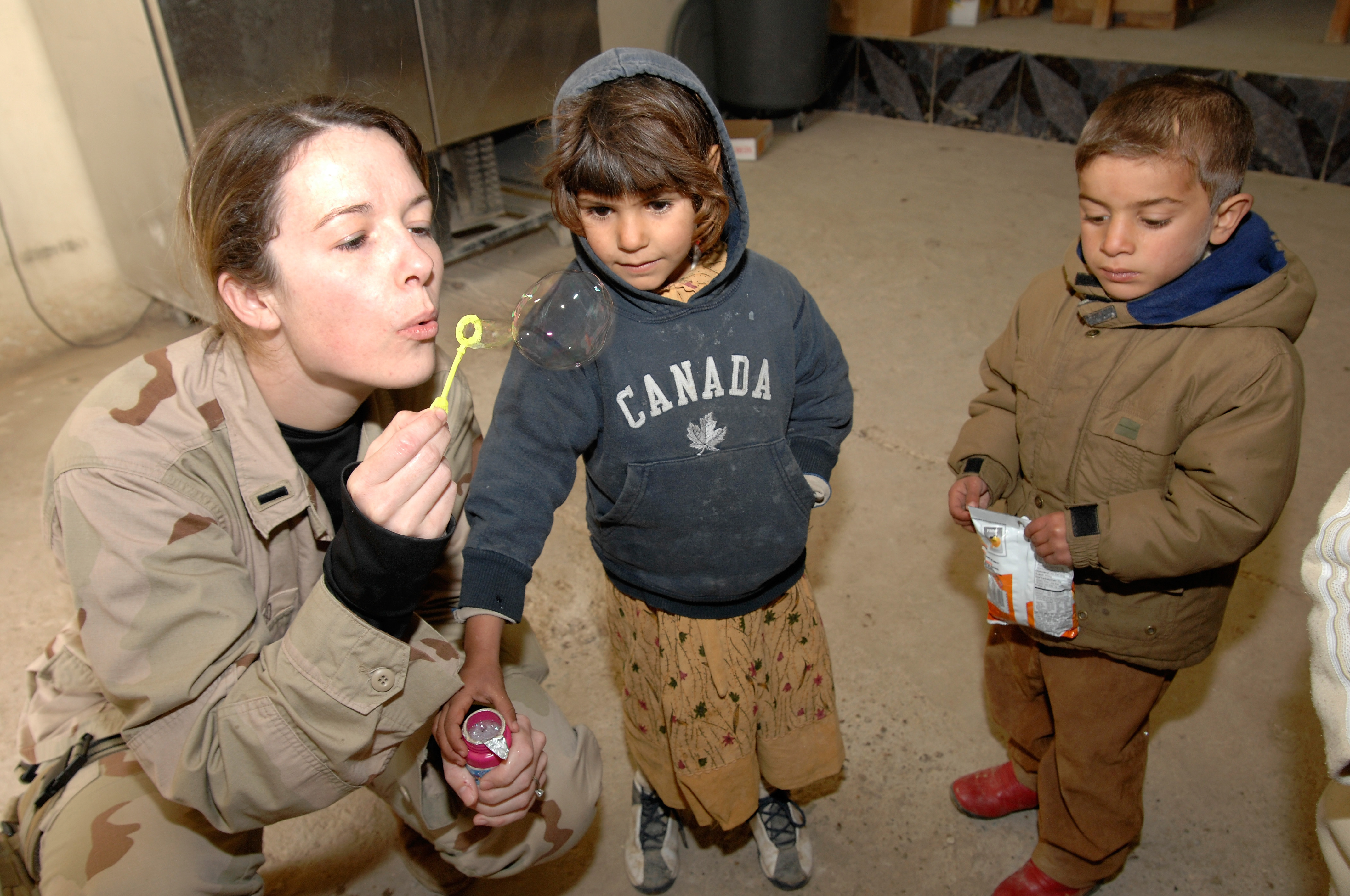 US Navy 070116-N-8218W-030 U.S. Air Force 1st Lt. Lea Ann Fracasso blows bubbles for some Iraqi children at the Civilian Military Operations Center (CMOC) near Baghdad, Iraq