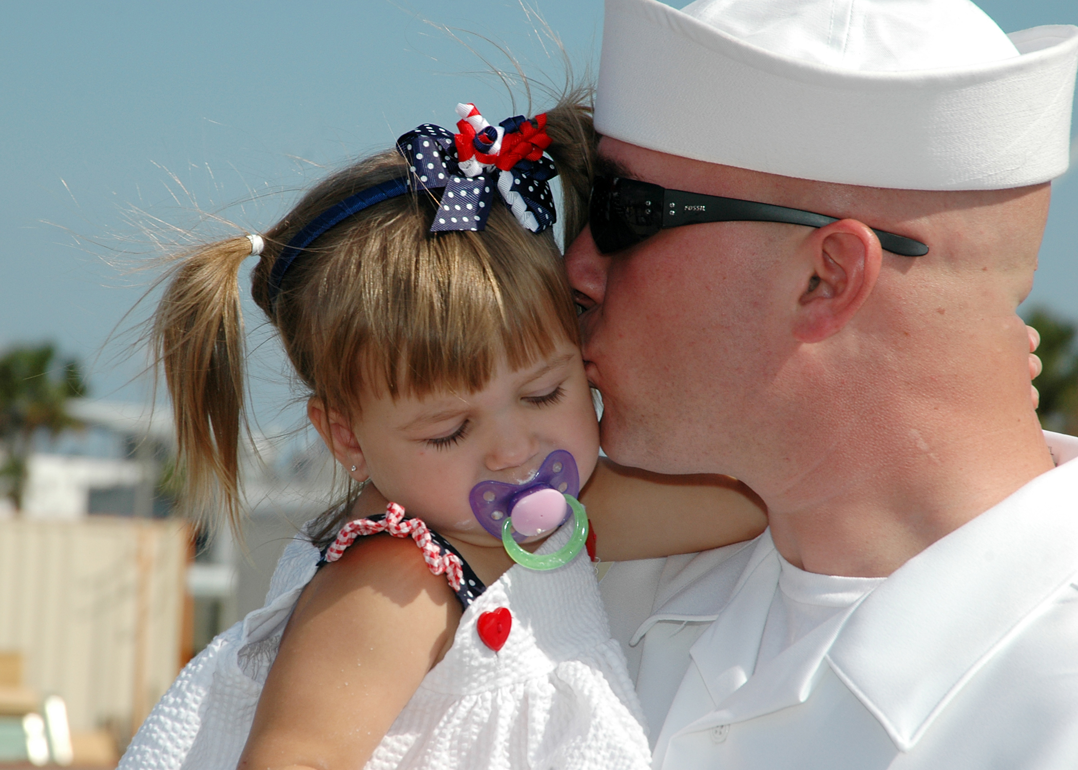 US Navy 081005-N-1522S-021 onar Technician 2nd Class Joseph Meadows kisses his daughter after after his return home aboard the guided-missile frigate USS McInerney (FFG 8) from a six-month deployment