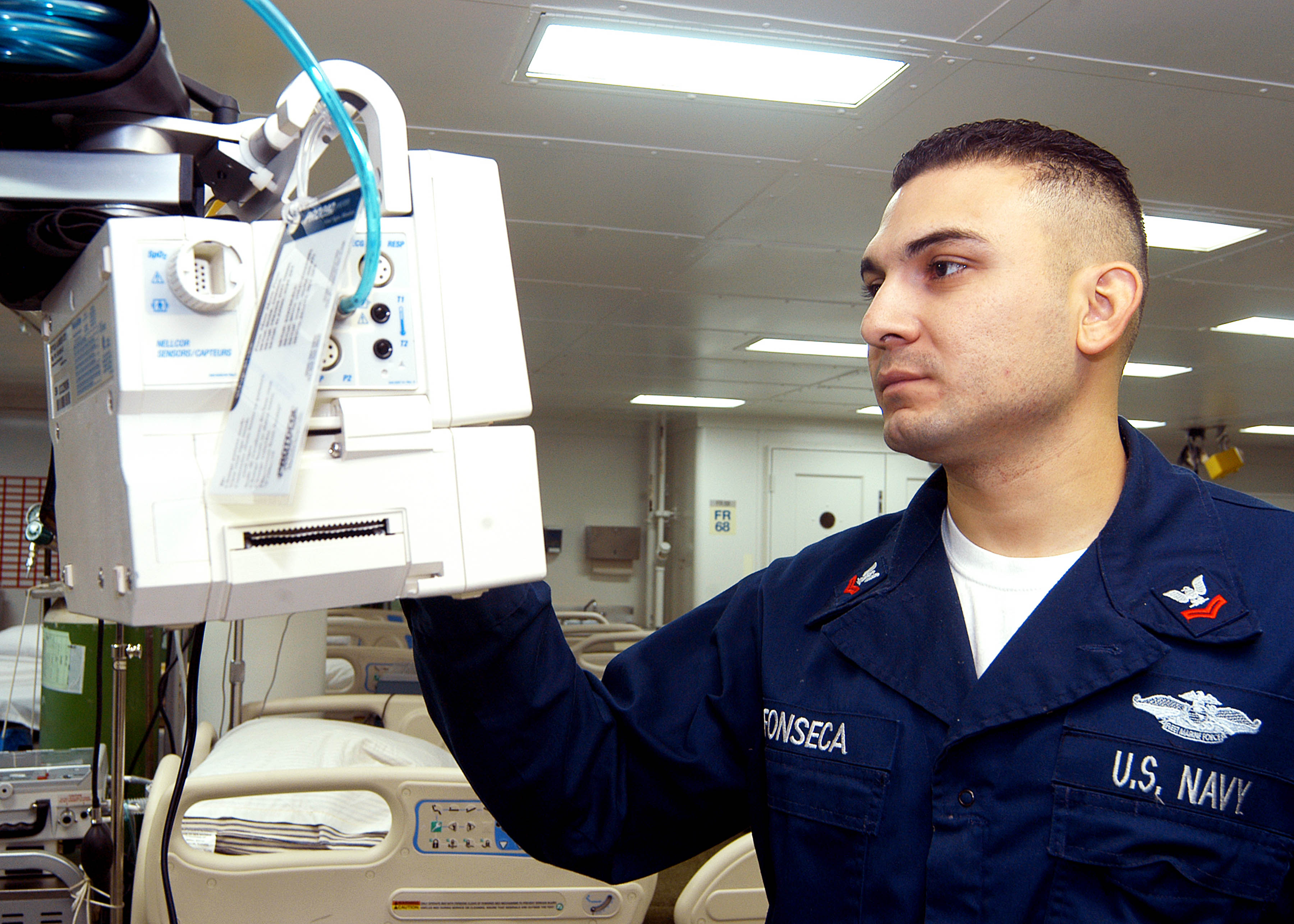 081125-D-9999F-001 - HM2 Luis Fonseca checks piece of medical equipment