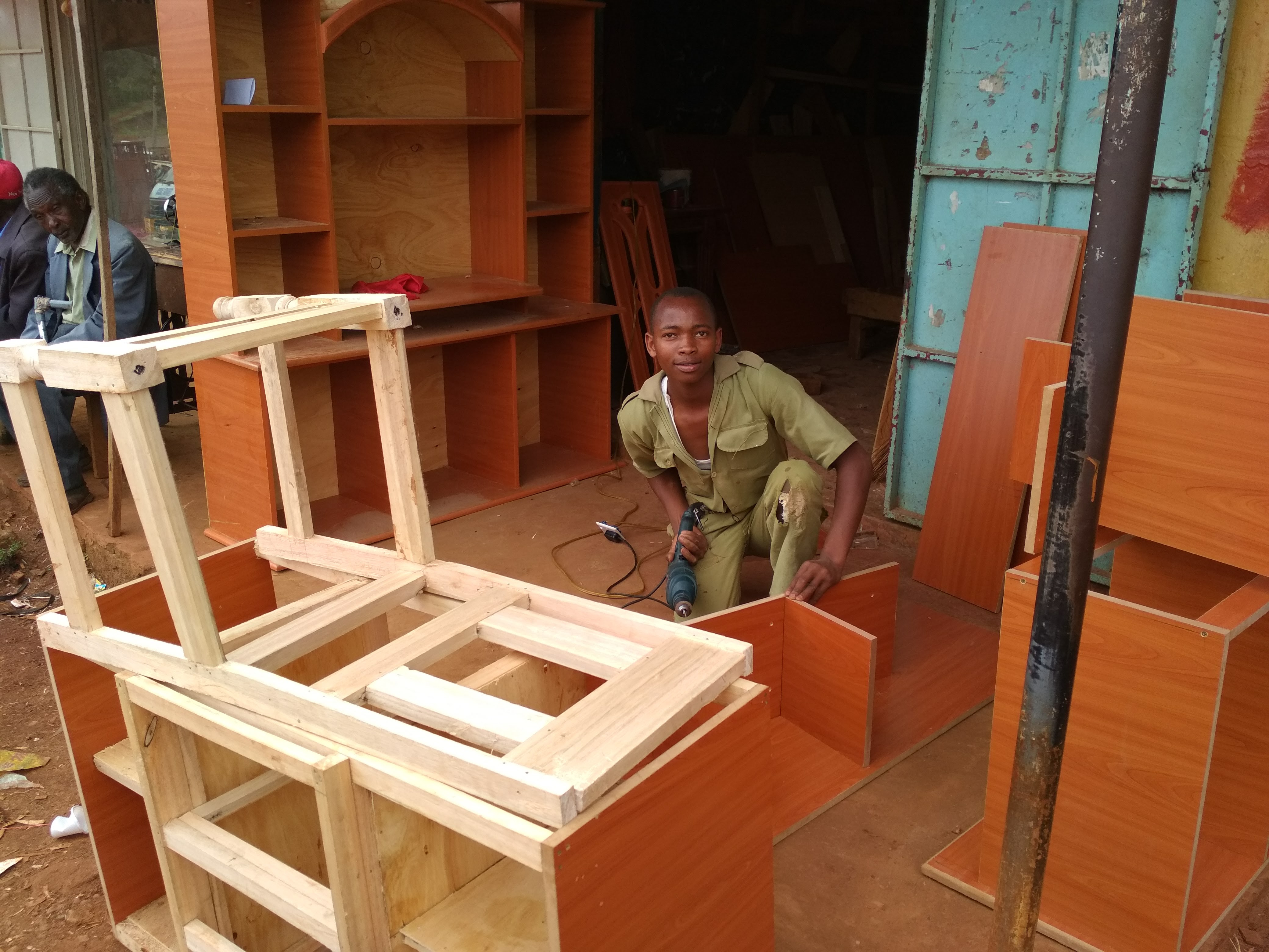 A young carpenter makes funiture outside a local workshop