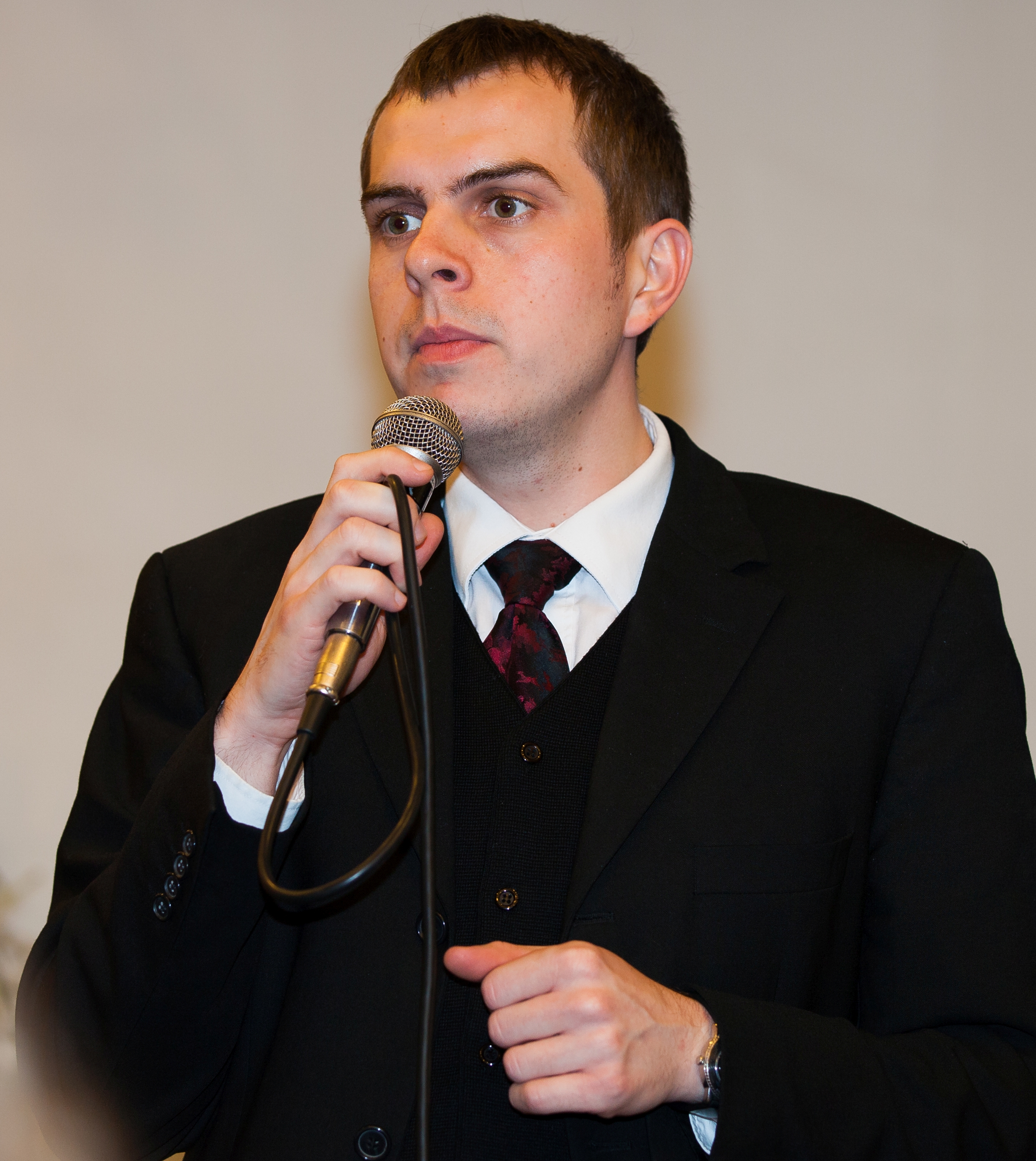 a young man with a microphone photographed in a Catholic chapel in November 2013