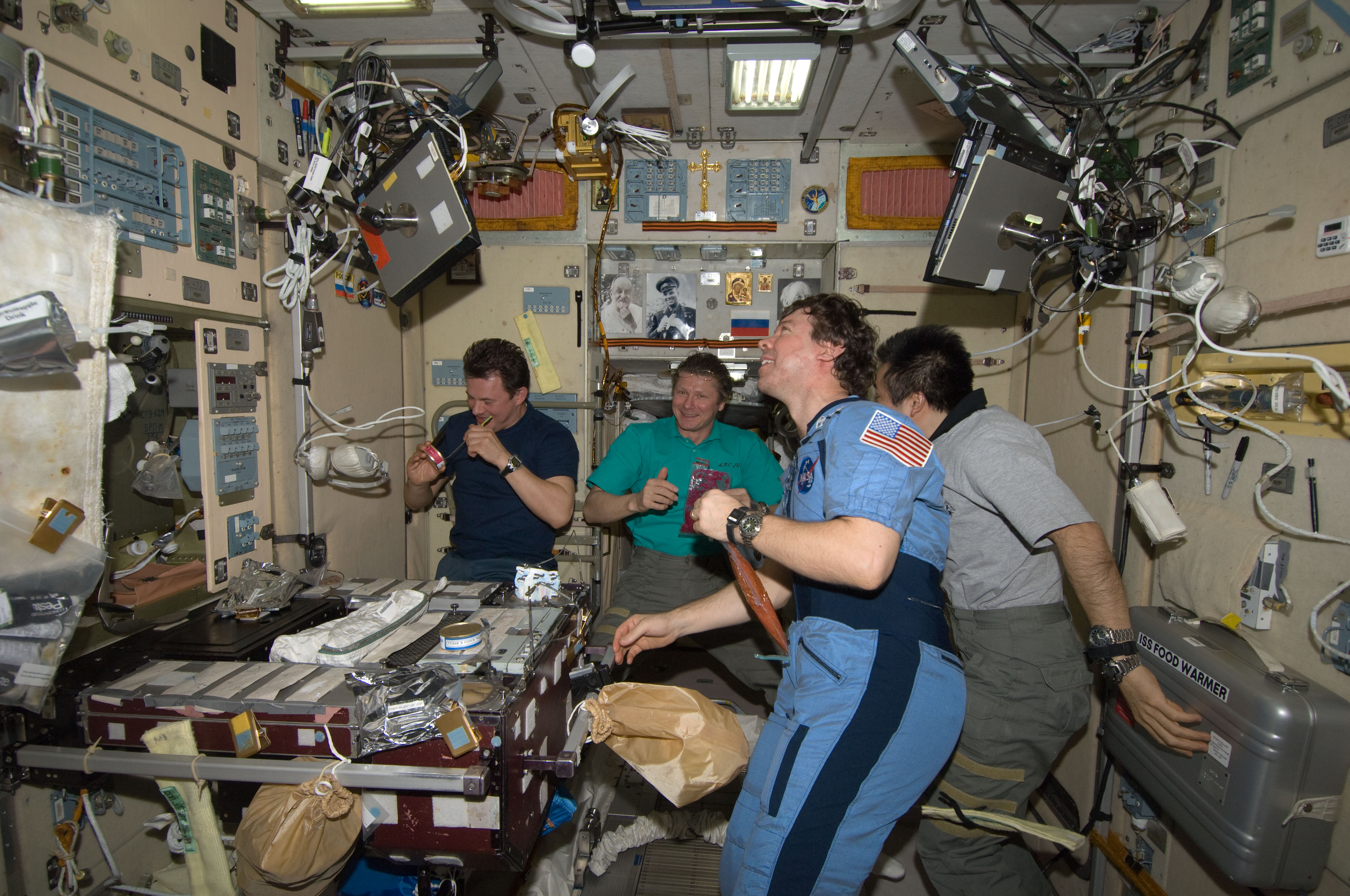 ISS-20 Crew members share a meal at the galley in the Zvezda Service Module