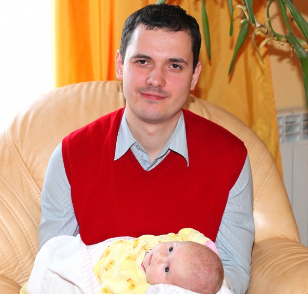 a handsome Catholic man with his baby daughter