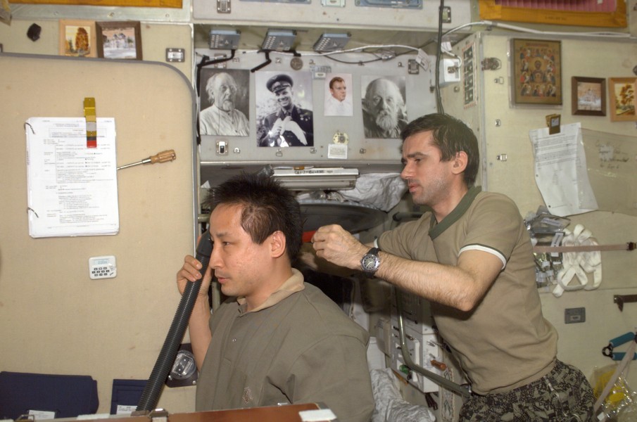 Cosmonaut Yuri I. Malenchenko cuts astronaut Edward T. Lu’s hair
