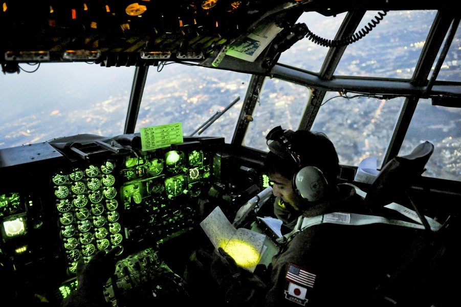 Defense.gov News Photo 110319-F-UI176-596 - U.S. Air Force Capt. Yuri Batten looks at a map while flying a C-130 Hercules filled with medical supplies over Yokota Japan on March 19 2011