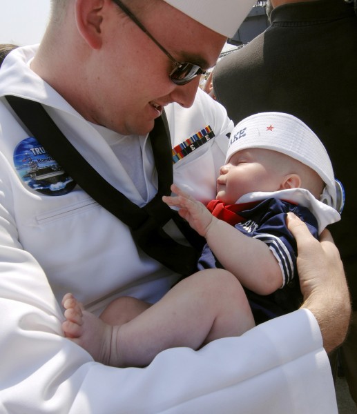 US Navy 080604-N-5345W-303 Aviation Boatswain's Mate (Handling) 3rd Class Nicholas Beyer holds his 4-month-old son for the first time during homecoming celebrations for the crew of the Nimitz-class aircraft carrier USS Harry S
