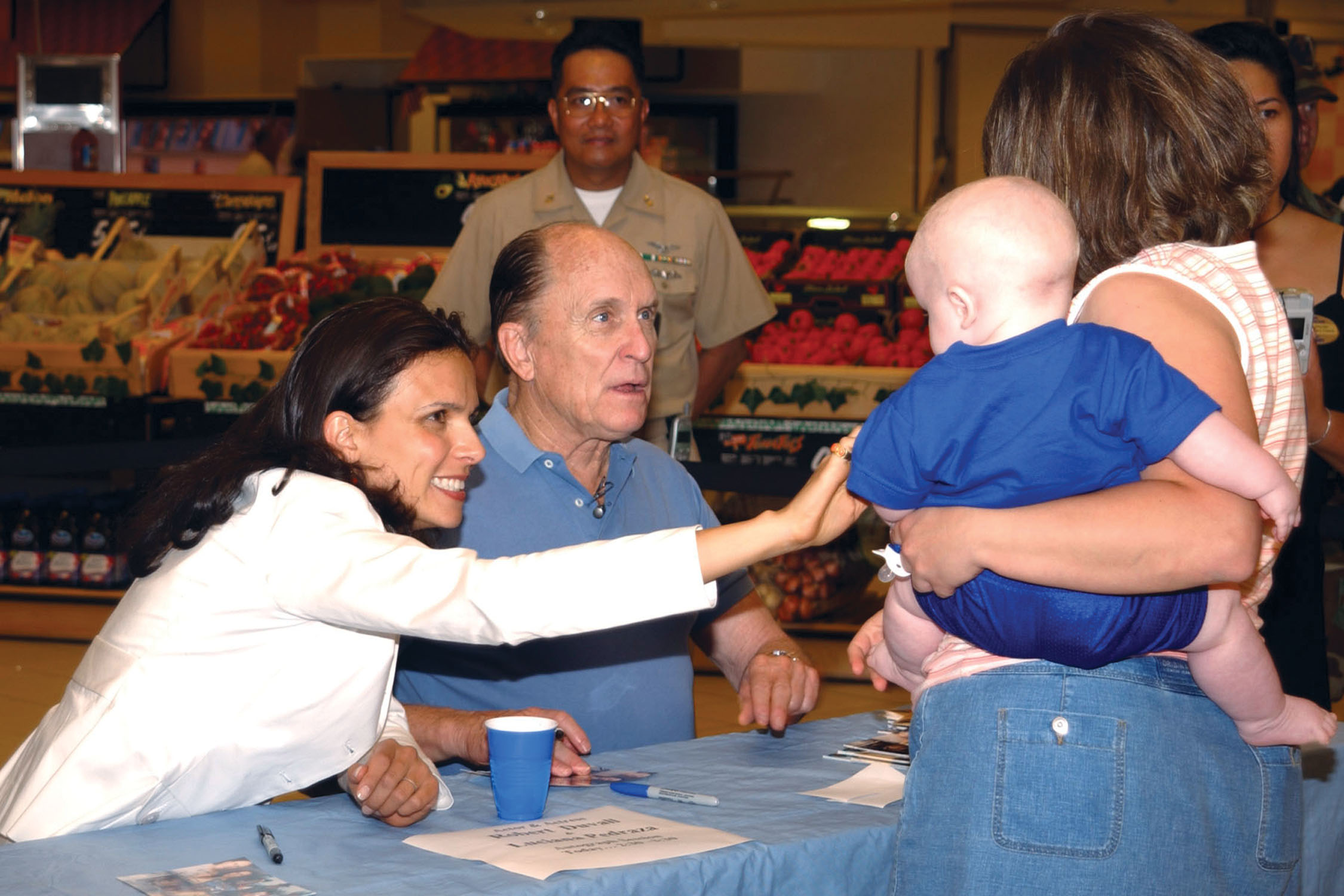 US Navy 030614-N-3983C-001 Actor-Writer-Director Robert Duvall and Actress Luciana Pedraza sign autographs in the Naval Air Station Sigonella Commissary for Sailors and their family members
