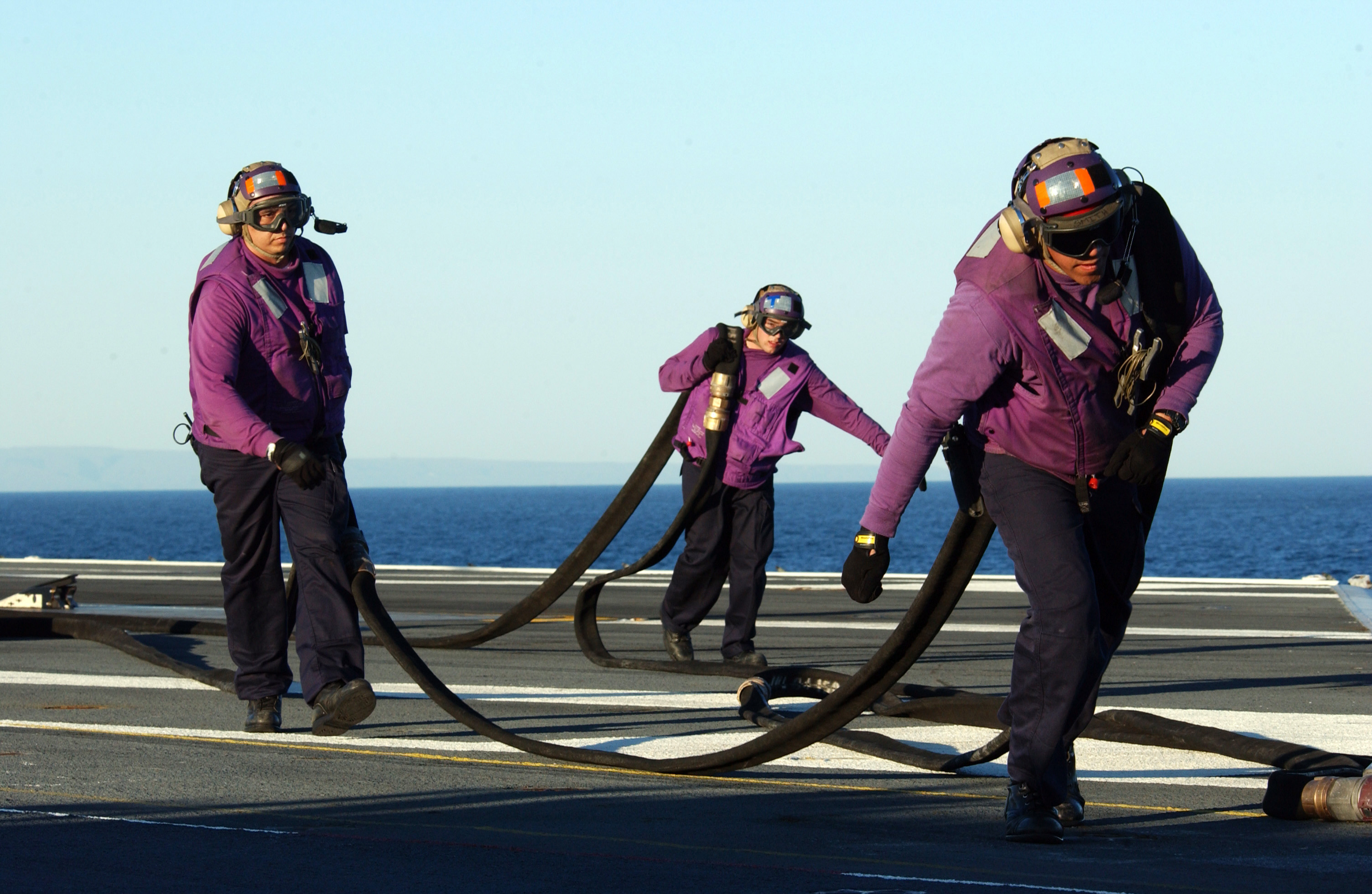 US Navy 050203-N-8148A-090 Aviation Boatswain's Mates return a fuel hose to its proper position after refueling an MH-60S Knighthawk helicopter