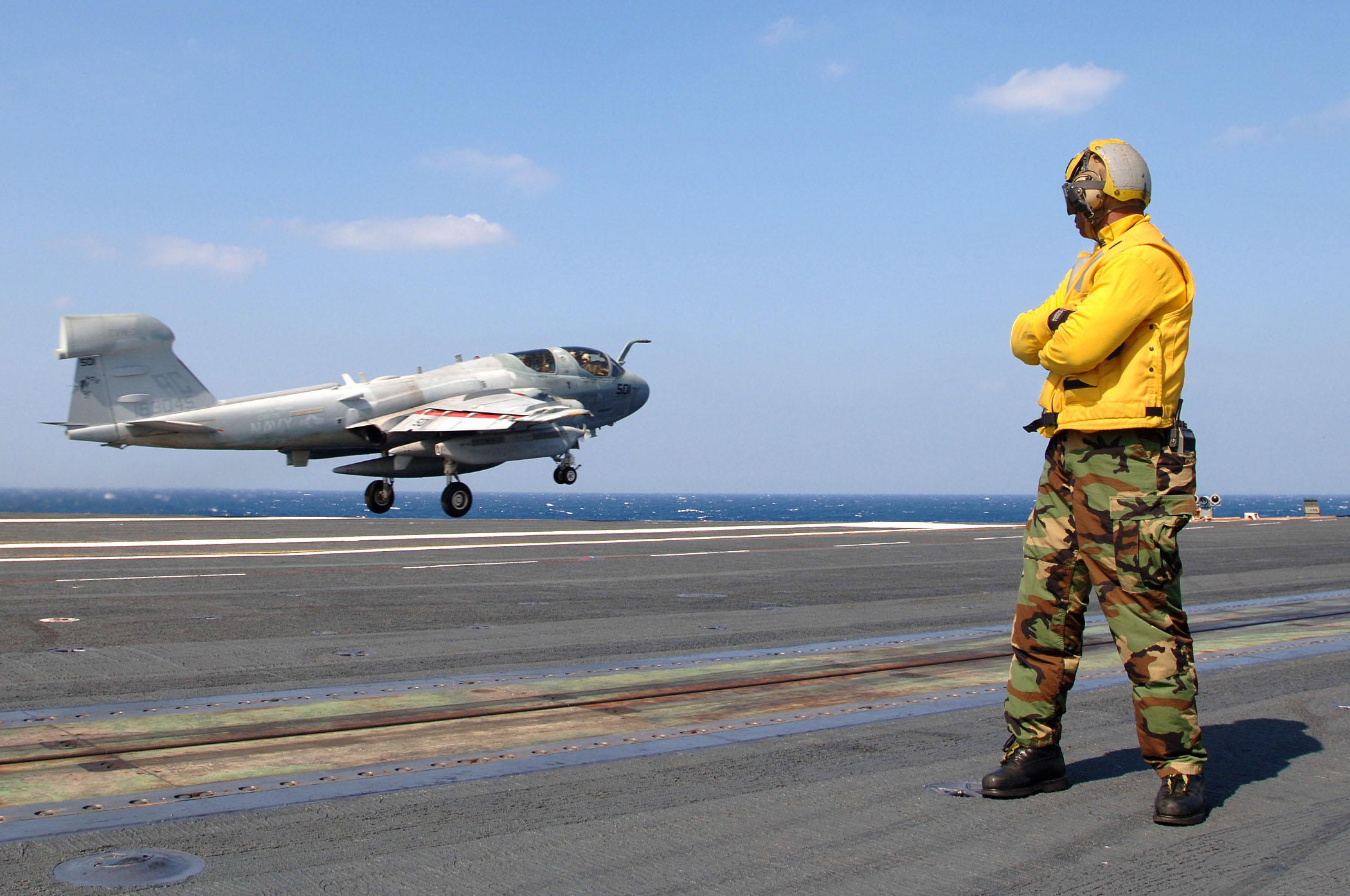 US Navy 051015-N-5345W-024 An Aviation Boatswain's Mate watches as an EA-6B Prowler, assigned to the Zappers of Electronic Warfare Squadron One Three Zero (VAQ-130), launches during flight operations