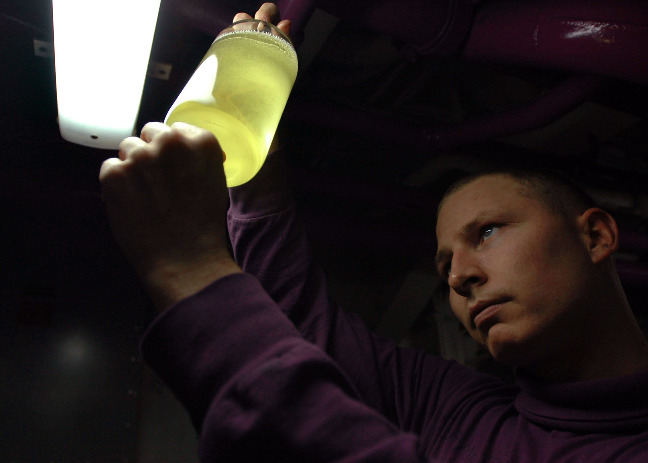 US Navy 070117-N-2659P-091 Aviation Boatswain's Mate (Fuel) 2nd Class Leo Meister inspects the quality of JP5 jet fuel in an aviation fuels pump room aboard USS John C. Stennis (CVN 74)