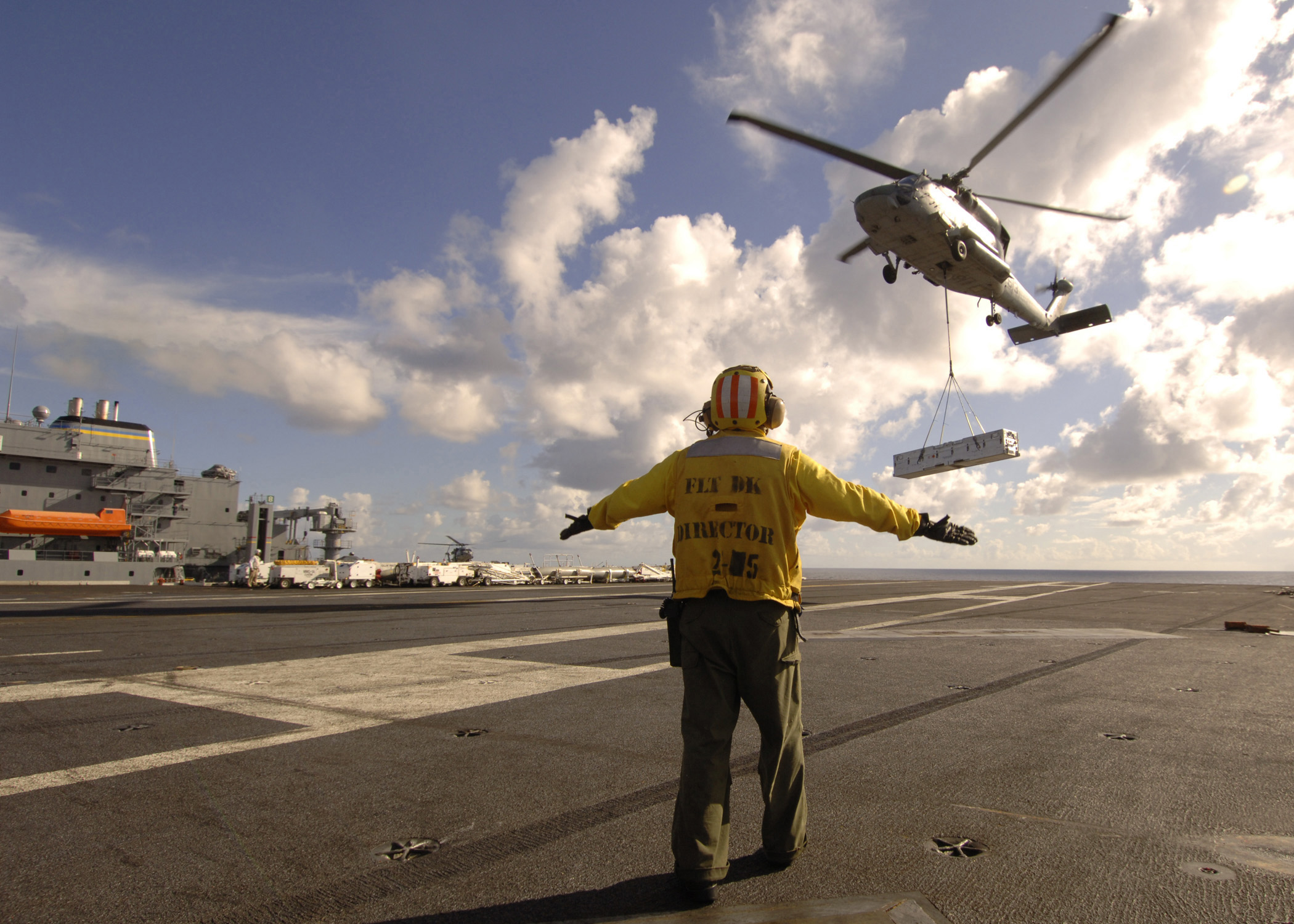 US Navy 080910-N-1161Z-082 Aviation Boatswain's Mate (Handling) 1st Class Kenji Kimura, assigned to the aircraft carrier USS George Washington (CVN 73), directs an SH-60F Sea Hawk helicopter