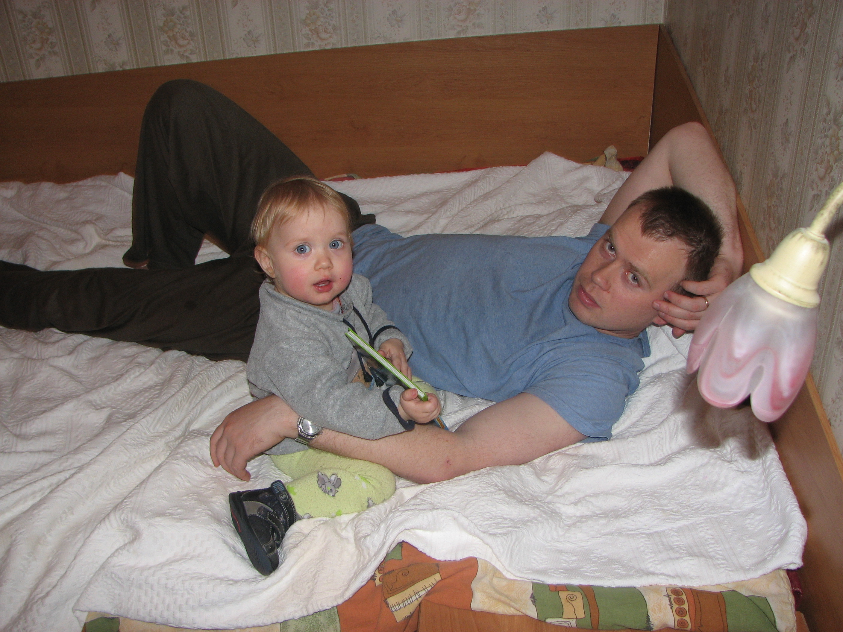 Father with his baby daughter on a bed