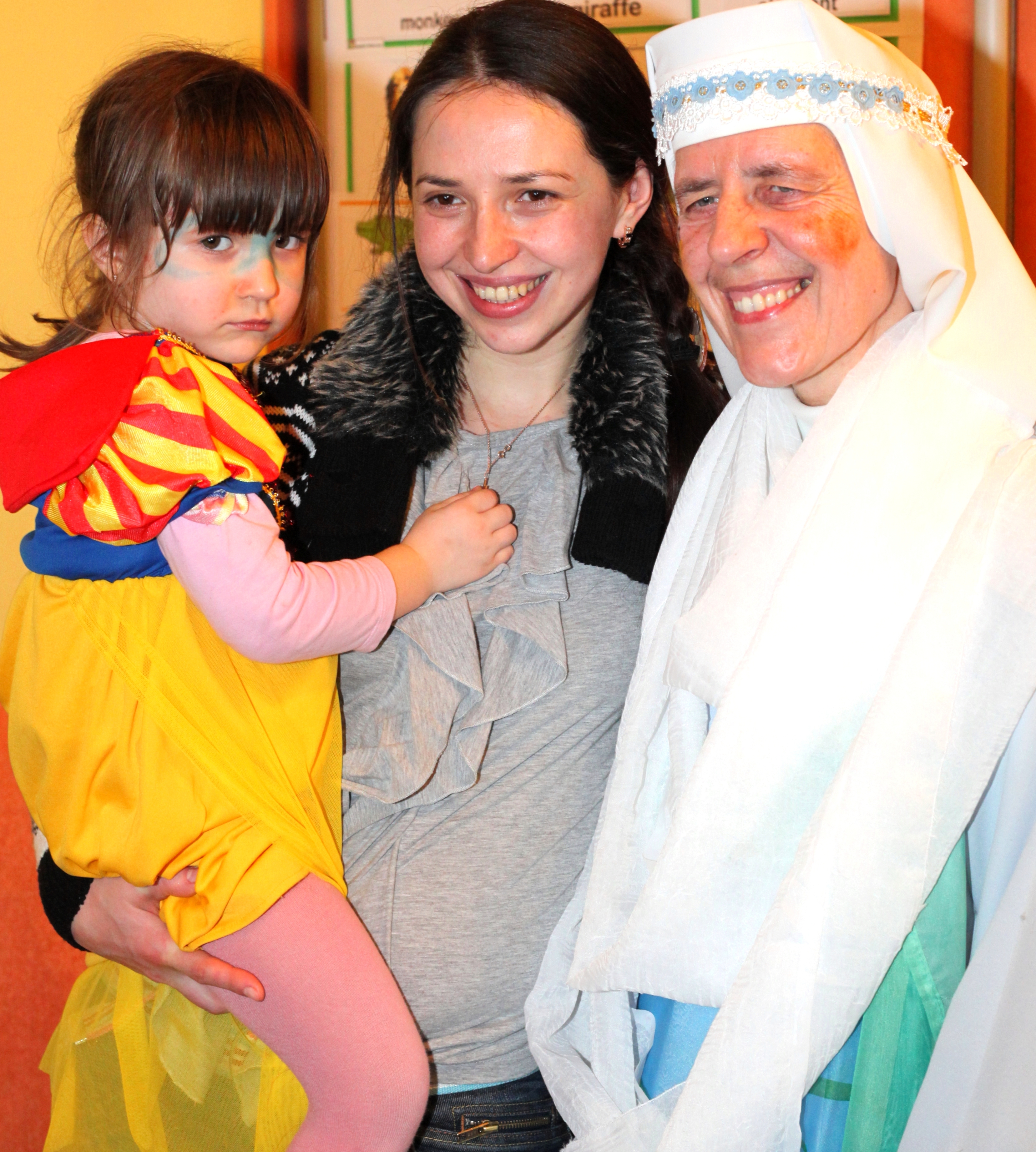 a beautiful brunette Catholic woman with her cute daughter and a nun in a Catholic kindergarten, photo 1