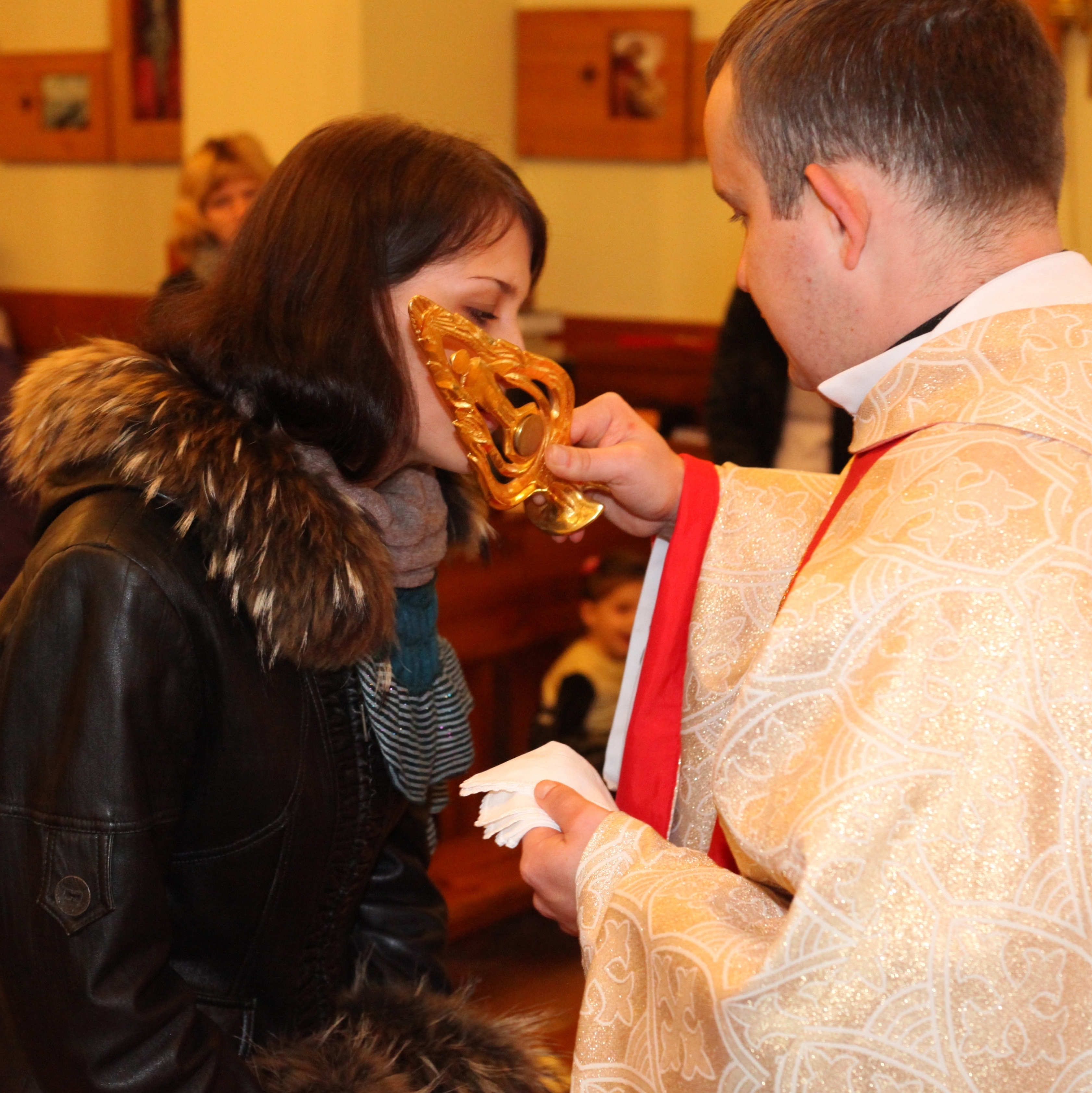 a beautiful brunette young Catholic woman in a Church kissing relics of a saint, photo 5