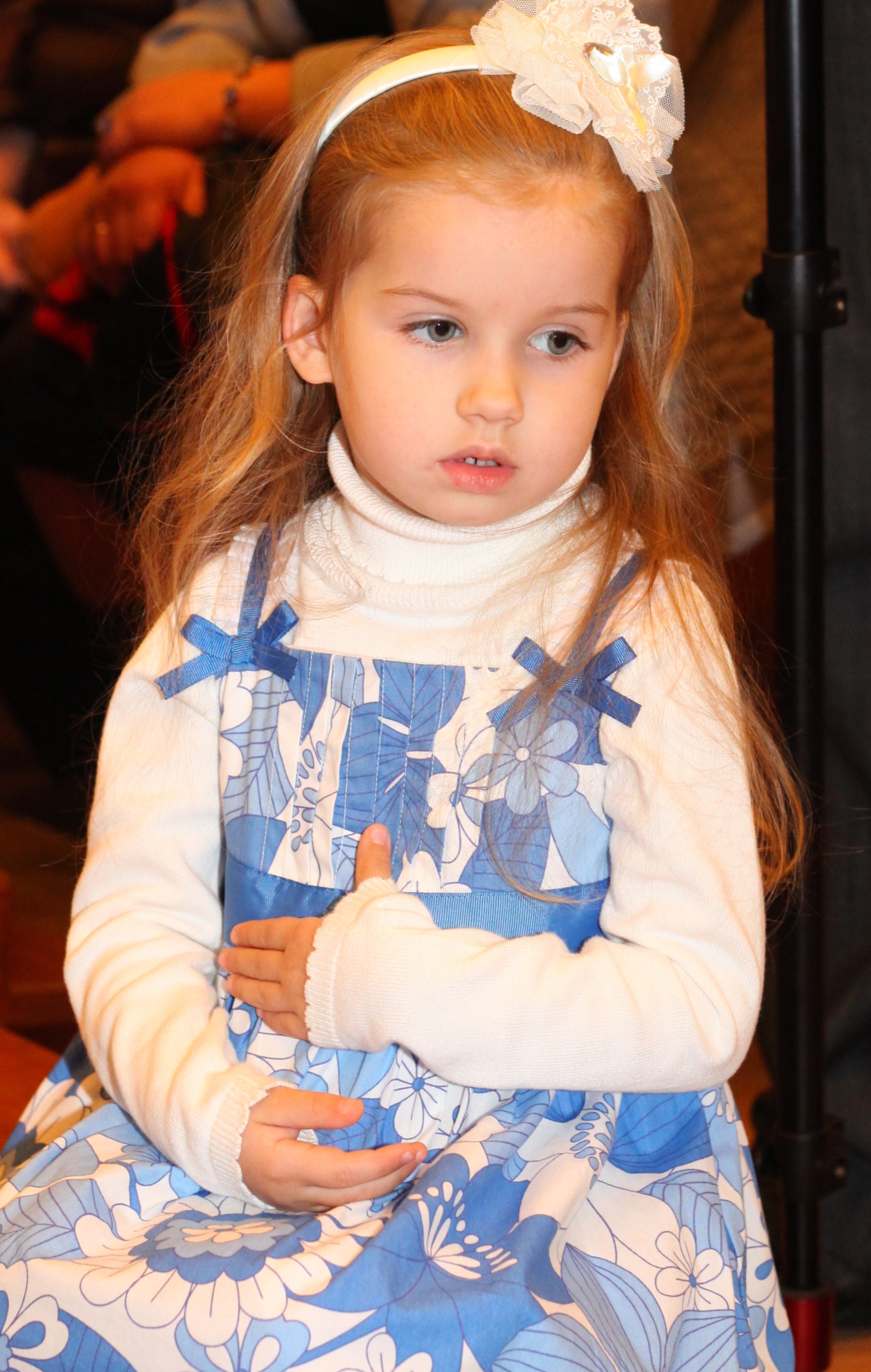 a cute beautiful charming Catholic child girl ina blue dress in a Church, photo 1